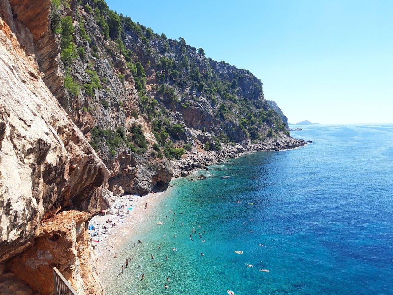 The pebble cove of Pasjaca at the foot of tall cliffs below Konavle in Croatia