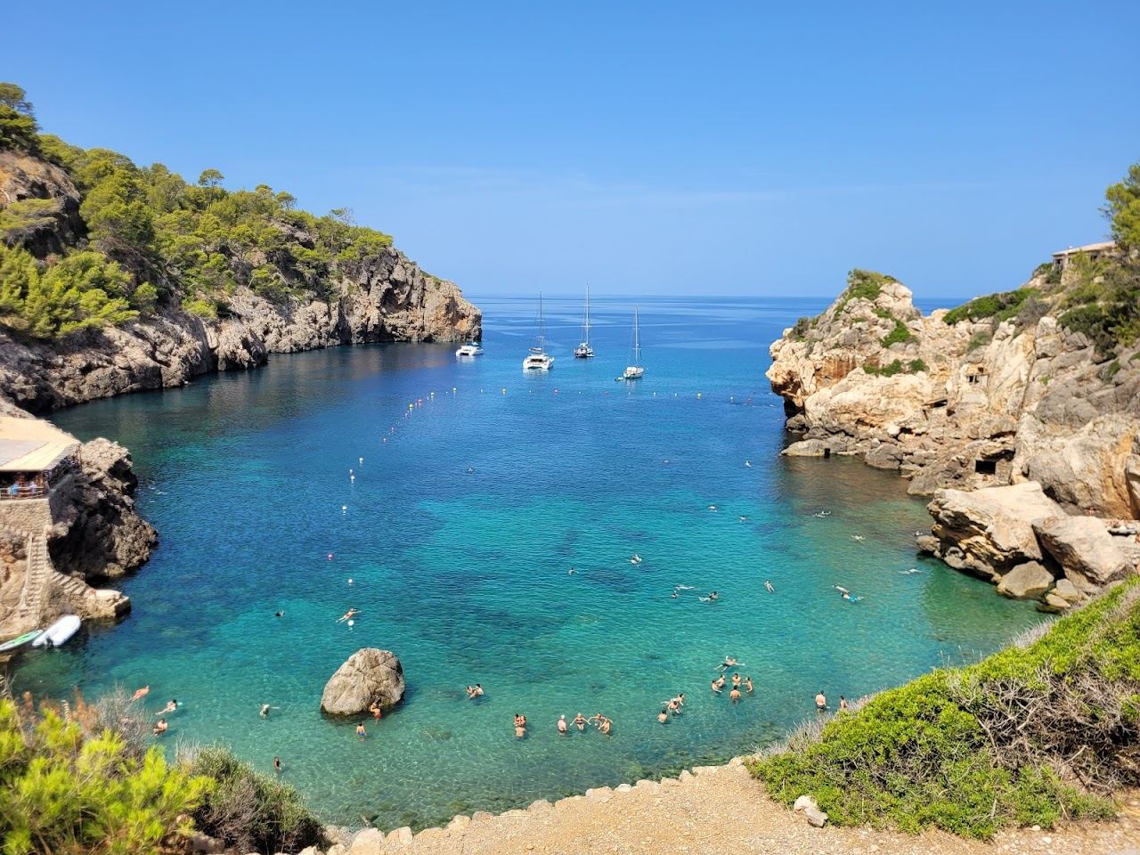 The pebble cove and deep clear water below the Tramuntana at Cala Deia in Mallorca