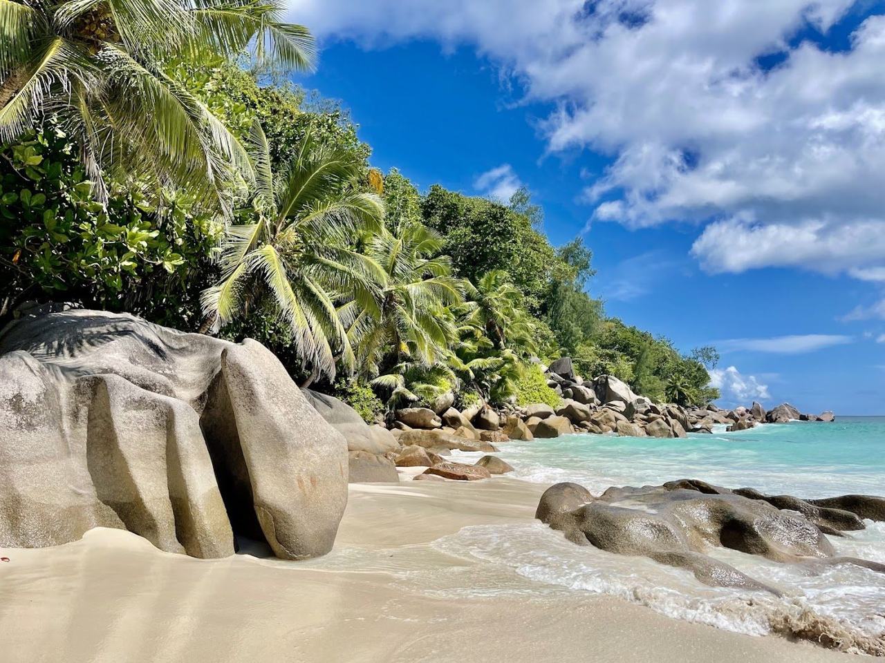 Pale sand and granite boulders framing the quiet Anse Georgette beach on Praslin in the Seychelles