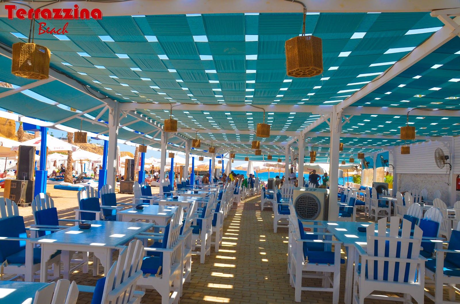Daybeds on the sand beside the clear Red Sea at a beach club in Sharm El Sheikh