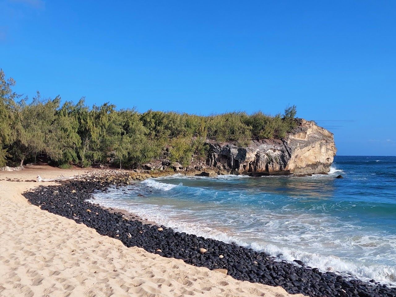 The limestone cliff of Makawehi Point rising above the surf at Shipwreck Beach in Poipu Kauai