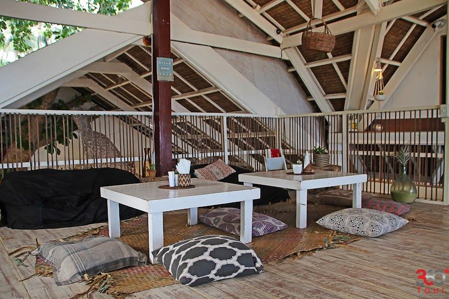 Daybeds and palm shade at White Banana Beach Club on Tuason Beach in Siargao