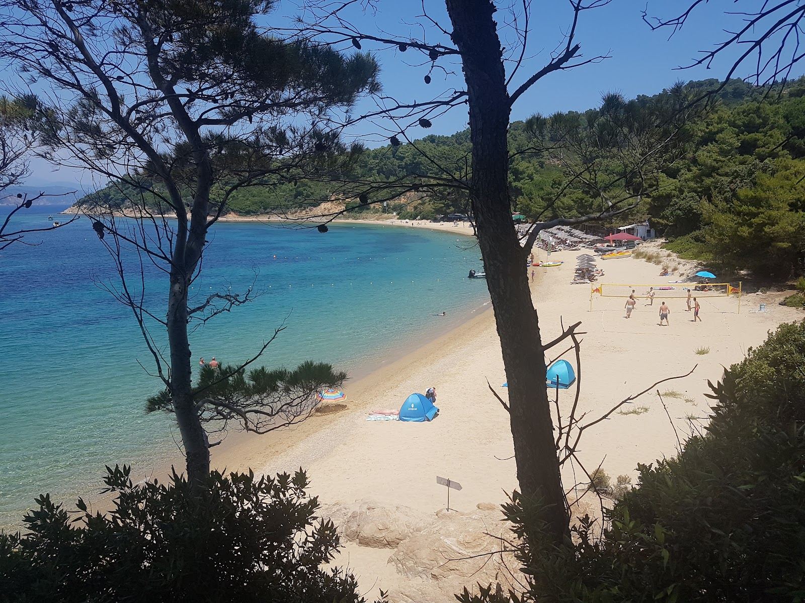 Evening light over the west facing sand and clear water of Agia Eleni beach on Skiathos in the Greek Sporades