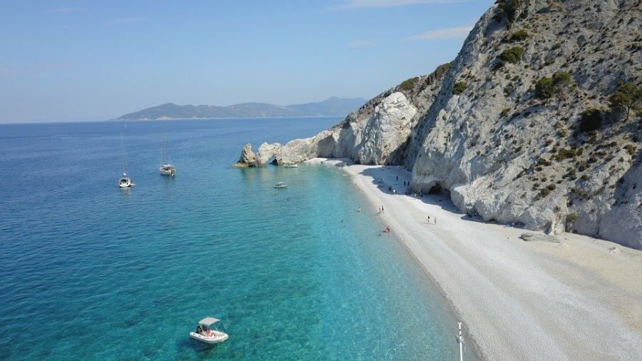 Smooth white pebbles and bright clear water beneath the cliffs of Lalaria beach on Skiathos