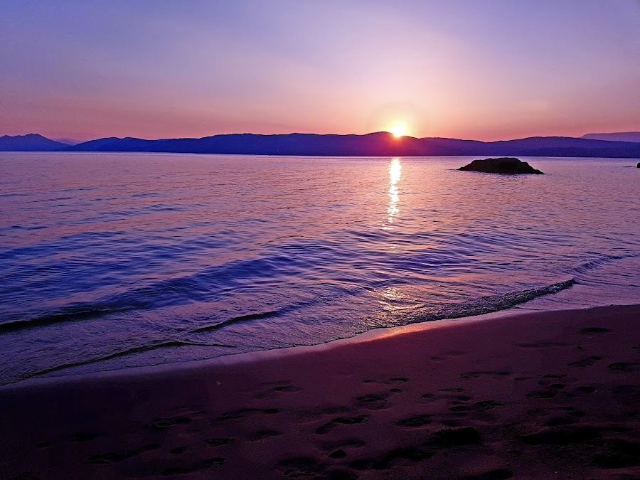 Clear calm water and gold sand in the small sheltered cove of Little Banana on Skiathos