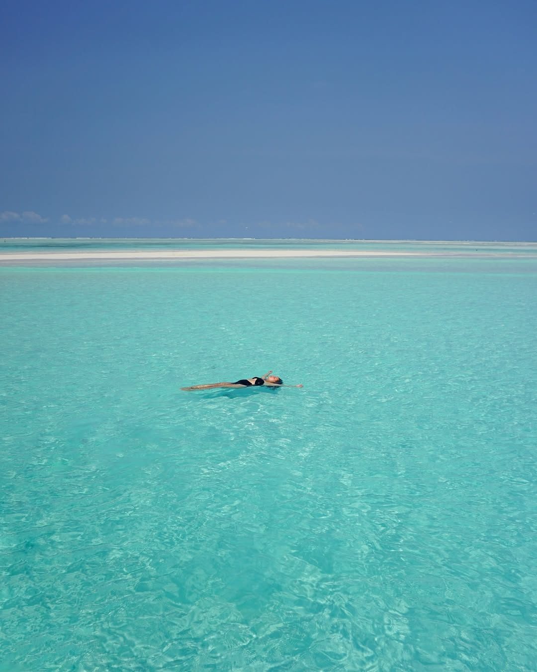 Clear turquoise water over a reef near a white sand beach on Zanzibar