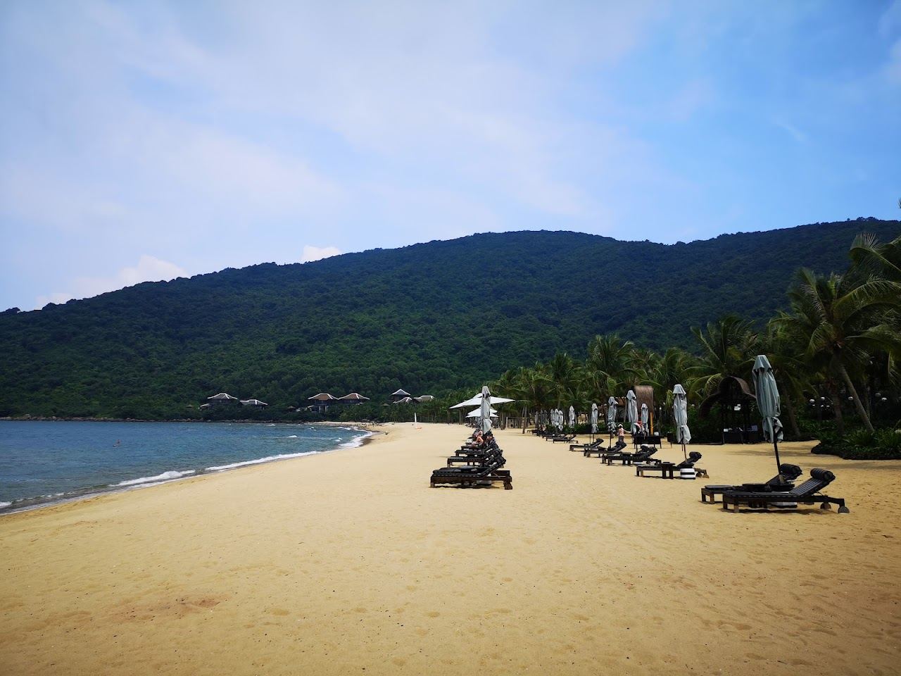 A secluded cove with clear water below the jungle hills of the Son Tra peninsula in Da Nang