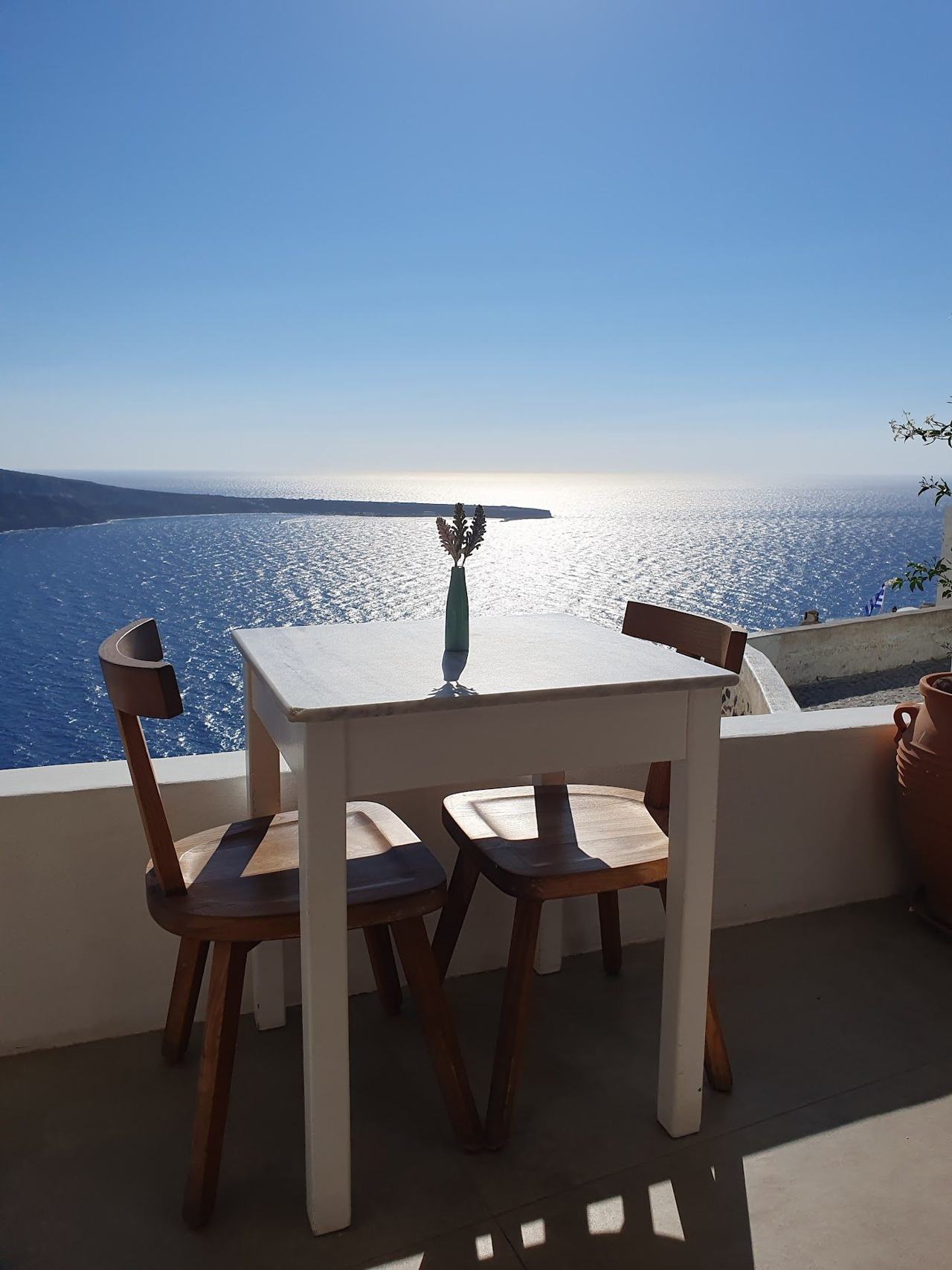 Whitewashed houses and the sea glowing gold as the sun sets over the caldera in Santorini