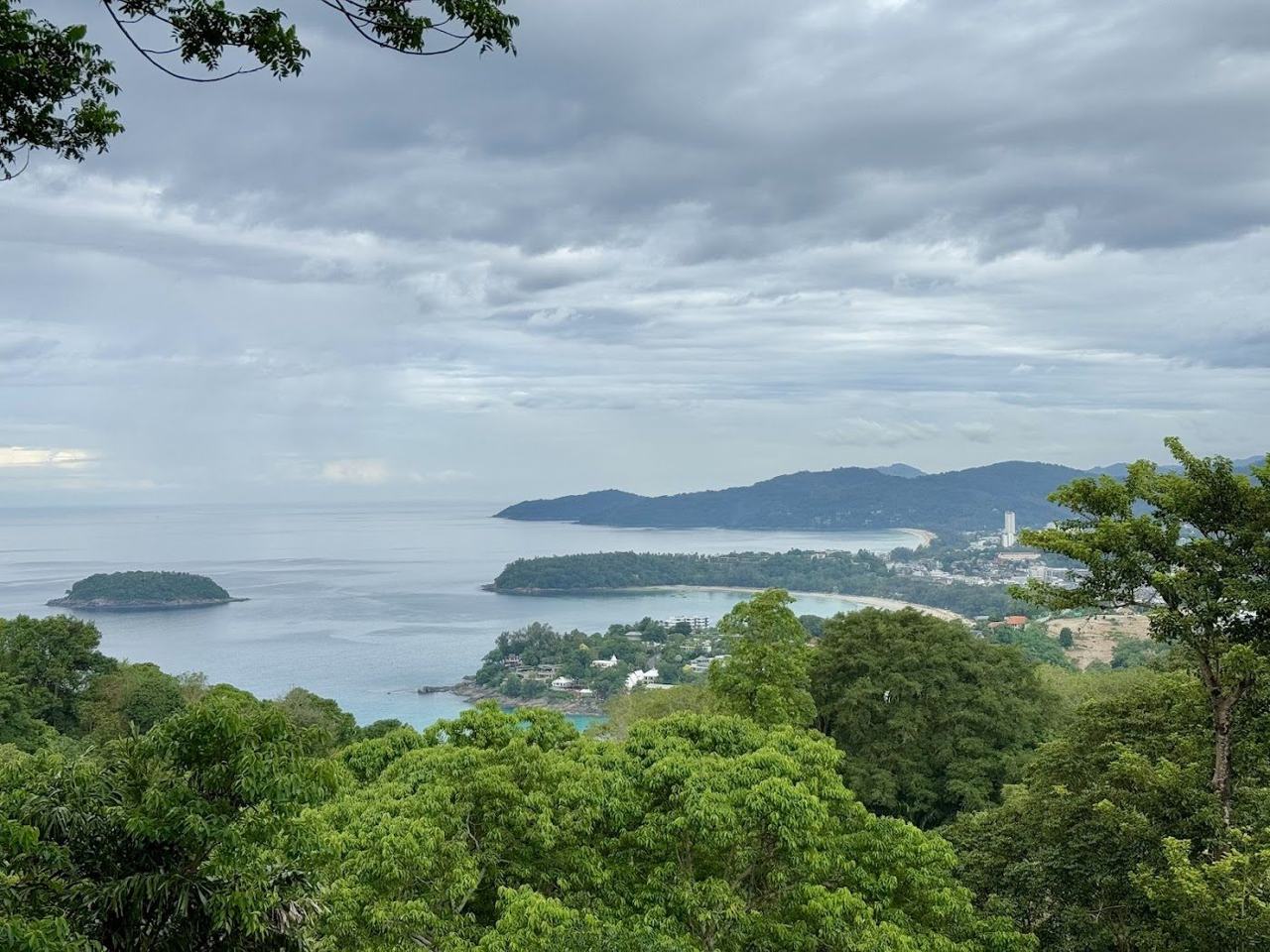 A curving west facing bay turning gold as the sun sets over the Andaman Sea in Phuket