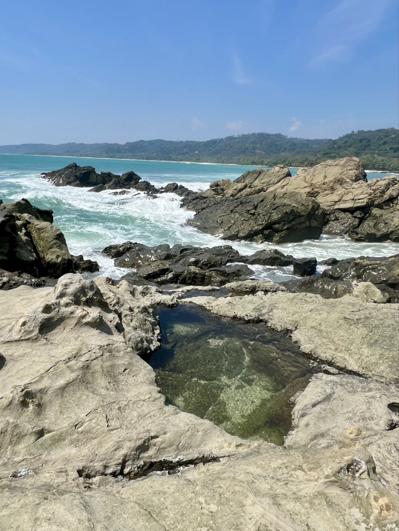 Surfers and natural pools at low tide at Mar Azul in Mal Pais Costa Rica