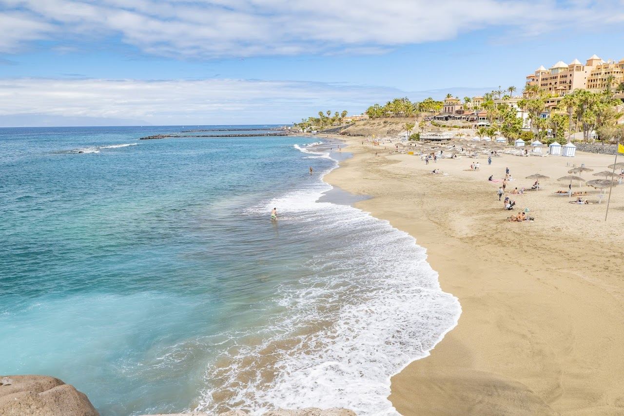 The golden sand and calm clear water of Playa del Duque in Costa Adeje Tenerife