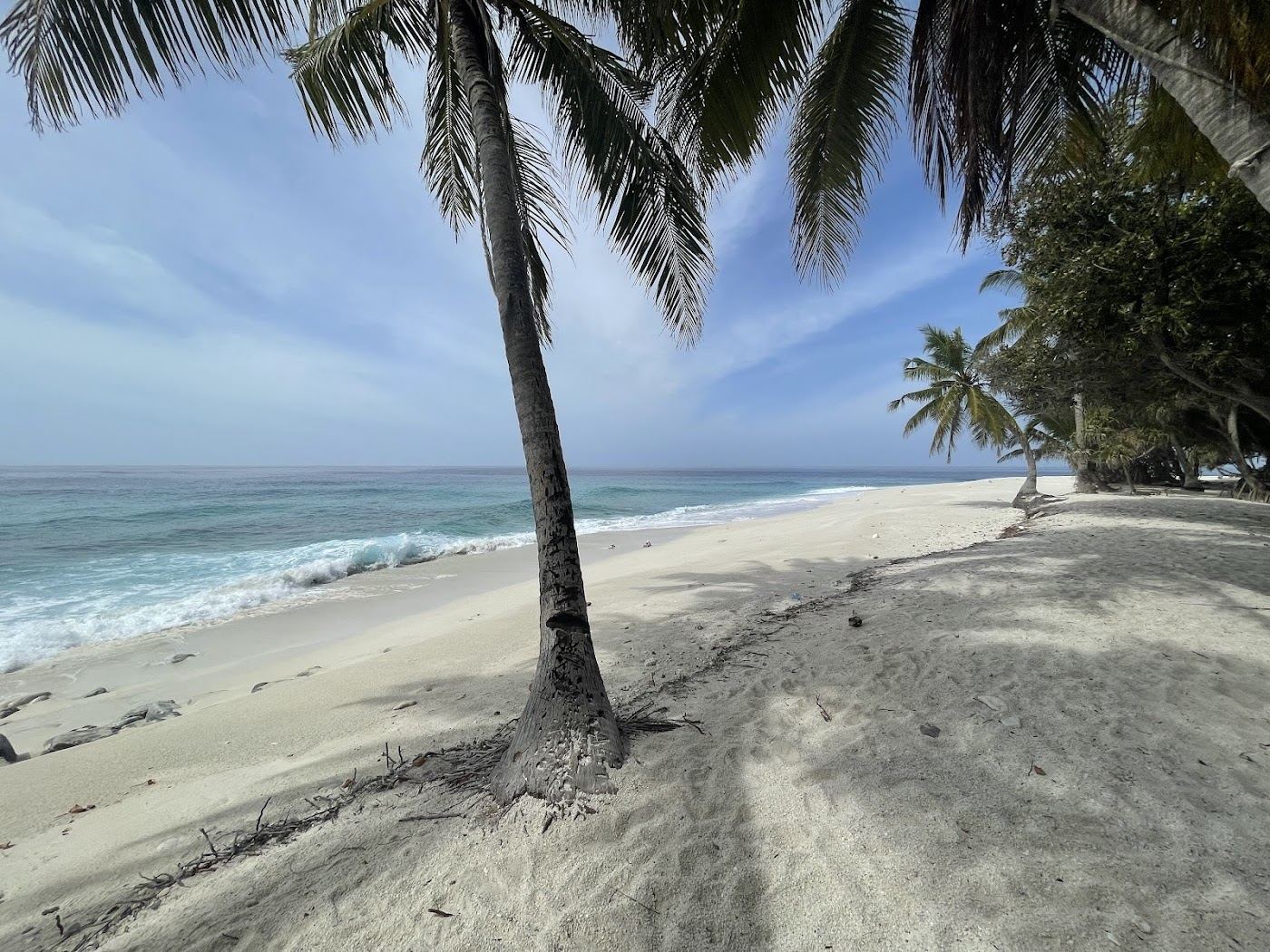 Smooth white coral pebbles and clear water at Thoondu beach on Fuvahmulah in the Maldives