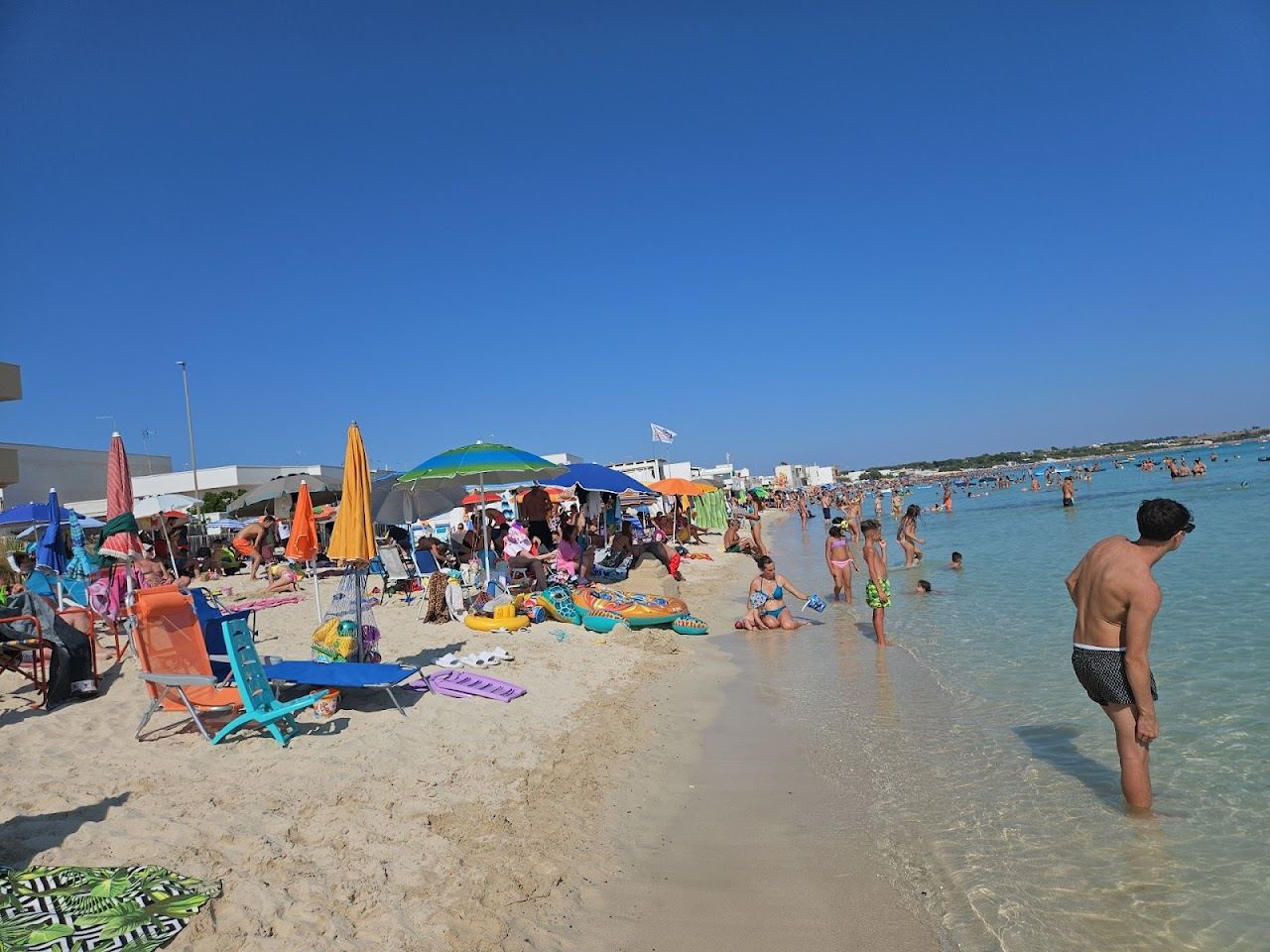 White sand and shallow turquoise water in the bay at Torre Lapillo near Porto Cesareo, Puglia