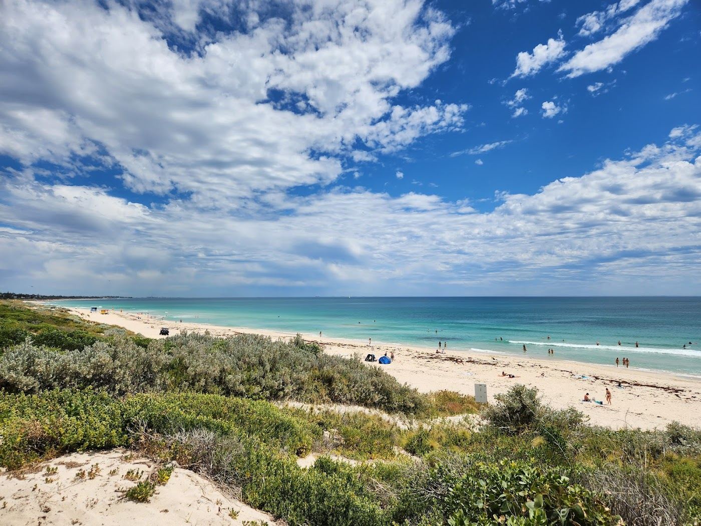 The reef fringed sand and breaking surf of Trigg Beach in Perth, Western Australia, with the limestone point beyond