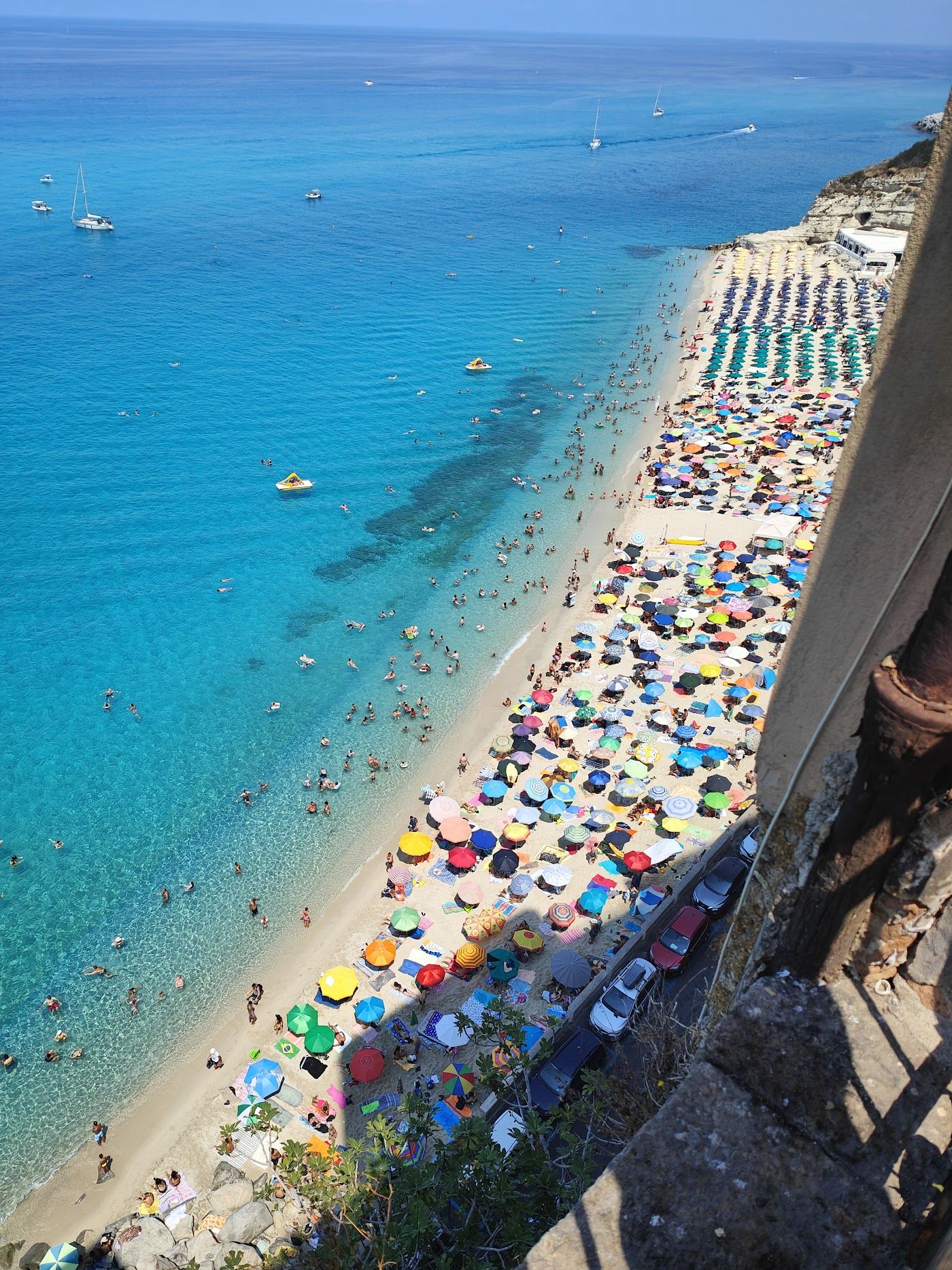 White sand and clear water below the cliff top old town of Tropea in Calabria