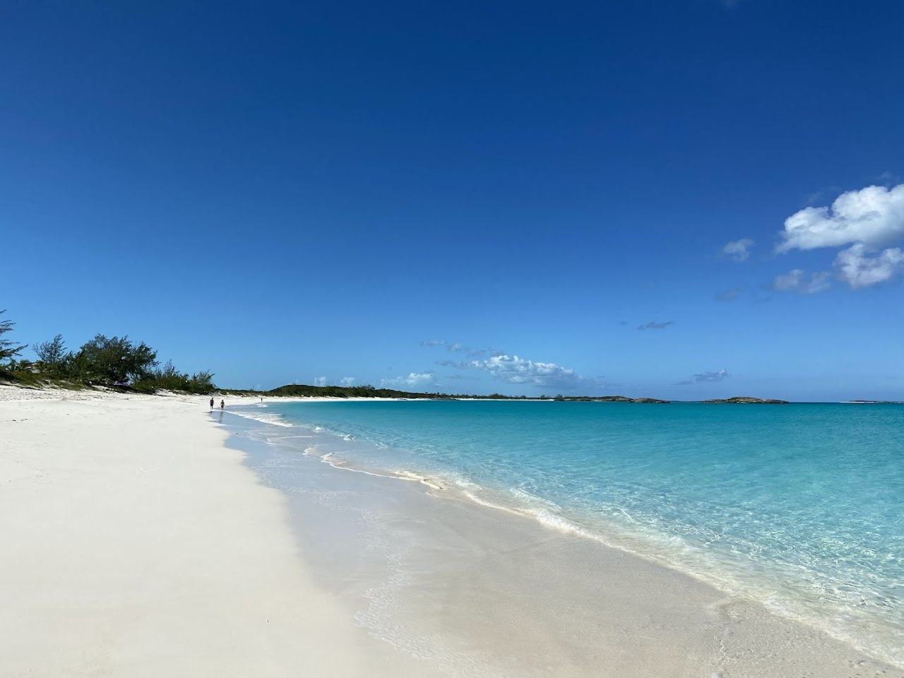 Long quiet crescent of white sand and clear turquoise water at Tropic of Cancer Beach on Little Exuma Bahamas