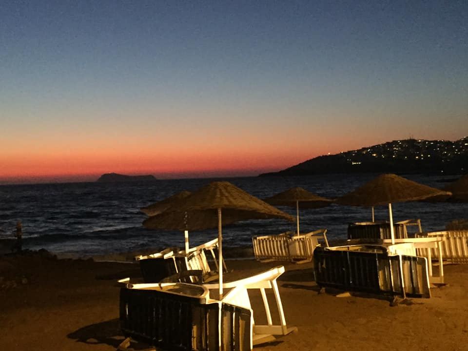 The sandy beach and sunset over the islands at Turgutreis in Bodrum