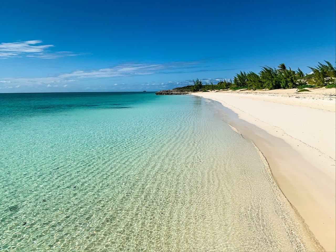 Loungers and calm turquoise water at a beachfront bar on Grace Bay in Turks and Caicos