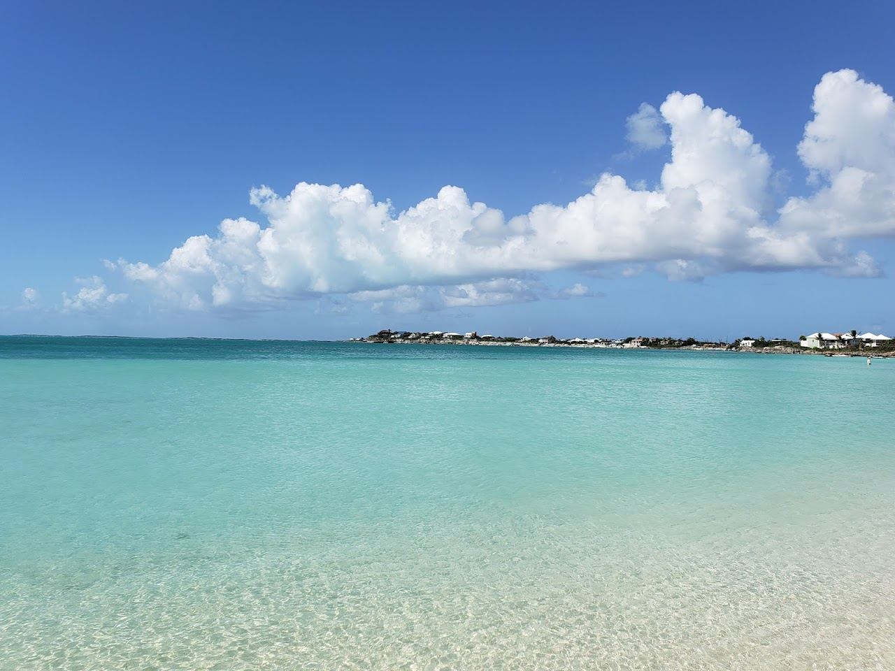 Shallow calm turquoise water and pale sand in soft evening light at Sapodilla Bay in Providenciales, Turks and Caicos