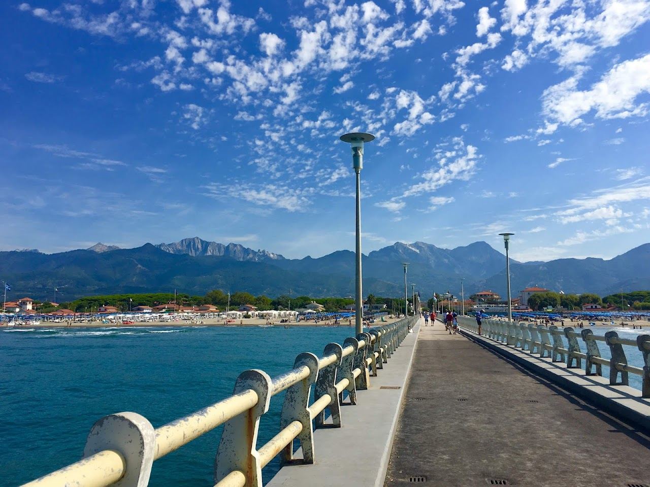 The pier and wide sandy beach at Forte dei Marmi with the Apuan Alps behind on the Tuscany coast