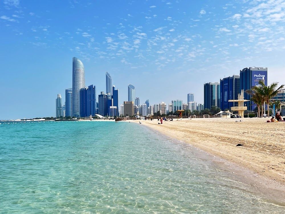Groomed Blue Flag sand and calm water with the skyline behind Corniche Beach in Abu Dhabi