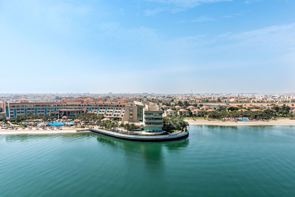 Sheltered lagoon water and hotel sand at the calm Al Raha Beach community near Abu Dhabi airport