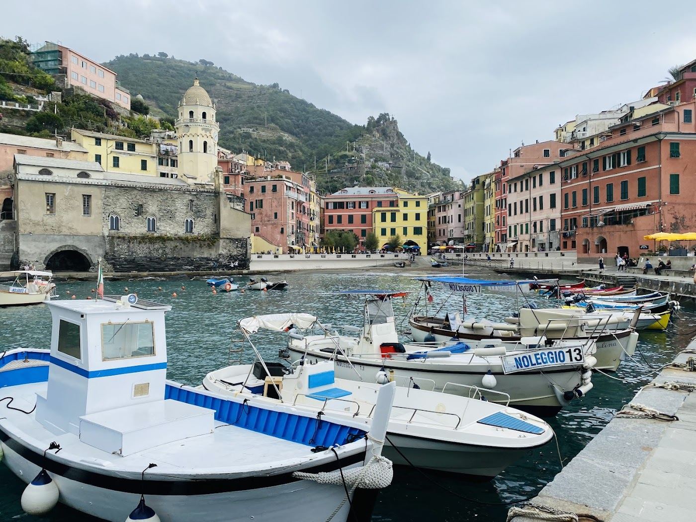 The pastel houses and church of Vernazza rising above its small Cinque Terre harbour