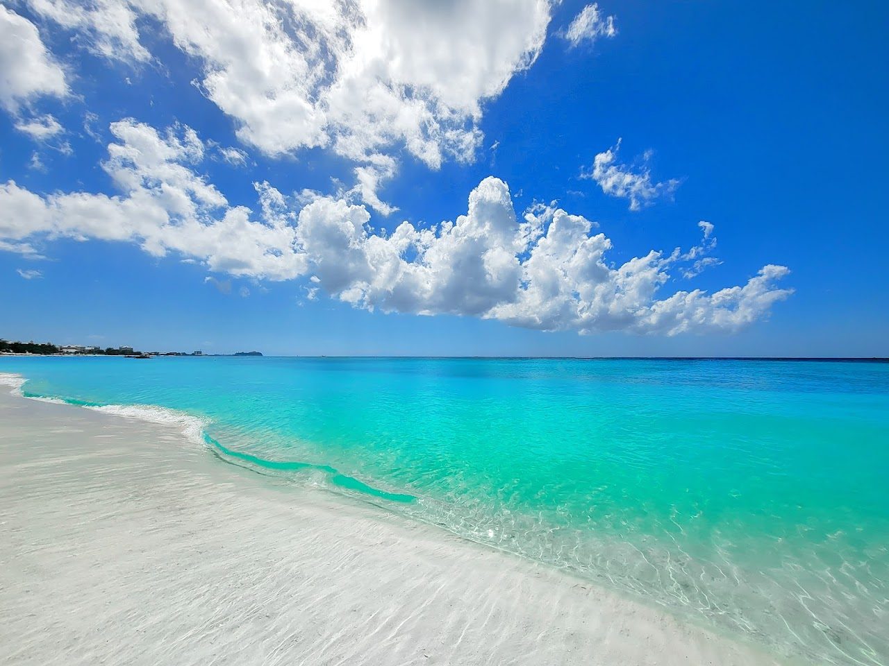 The calm clear water and coral sand of Seven Mile Beach on Grand Cayman