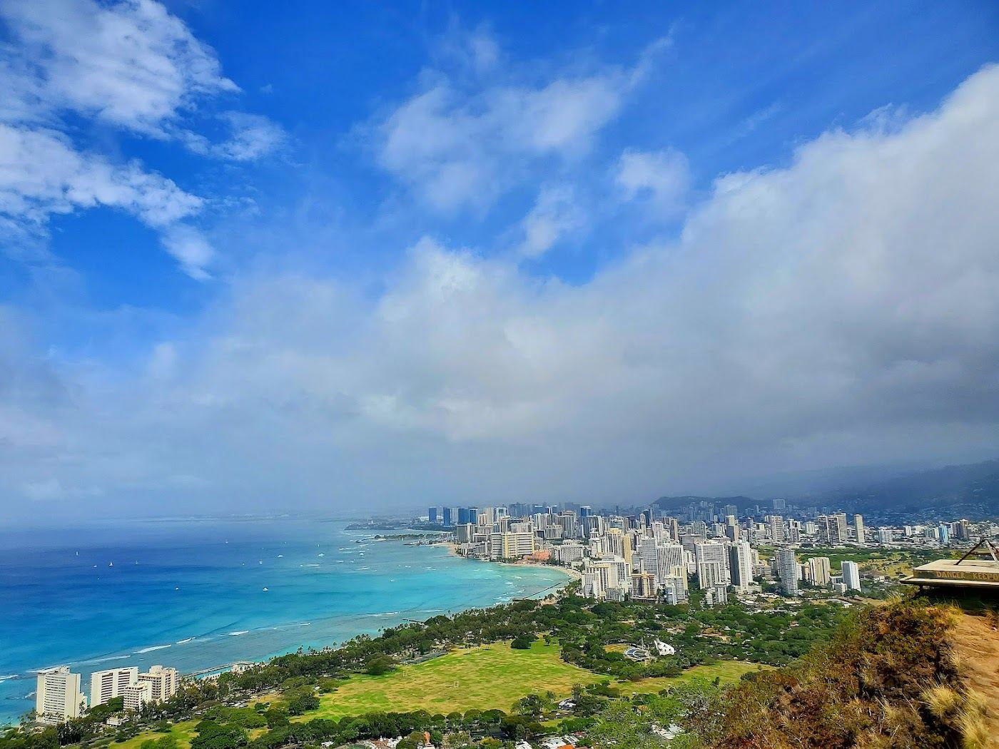 Waikiki Beach with calm water, surfers and Diamond Head crater behind the high rise hotels