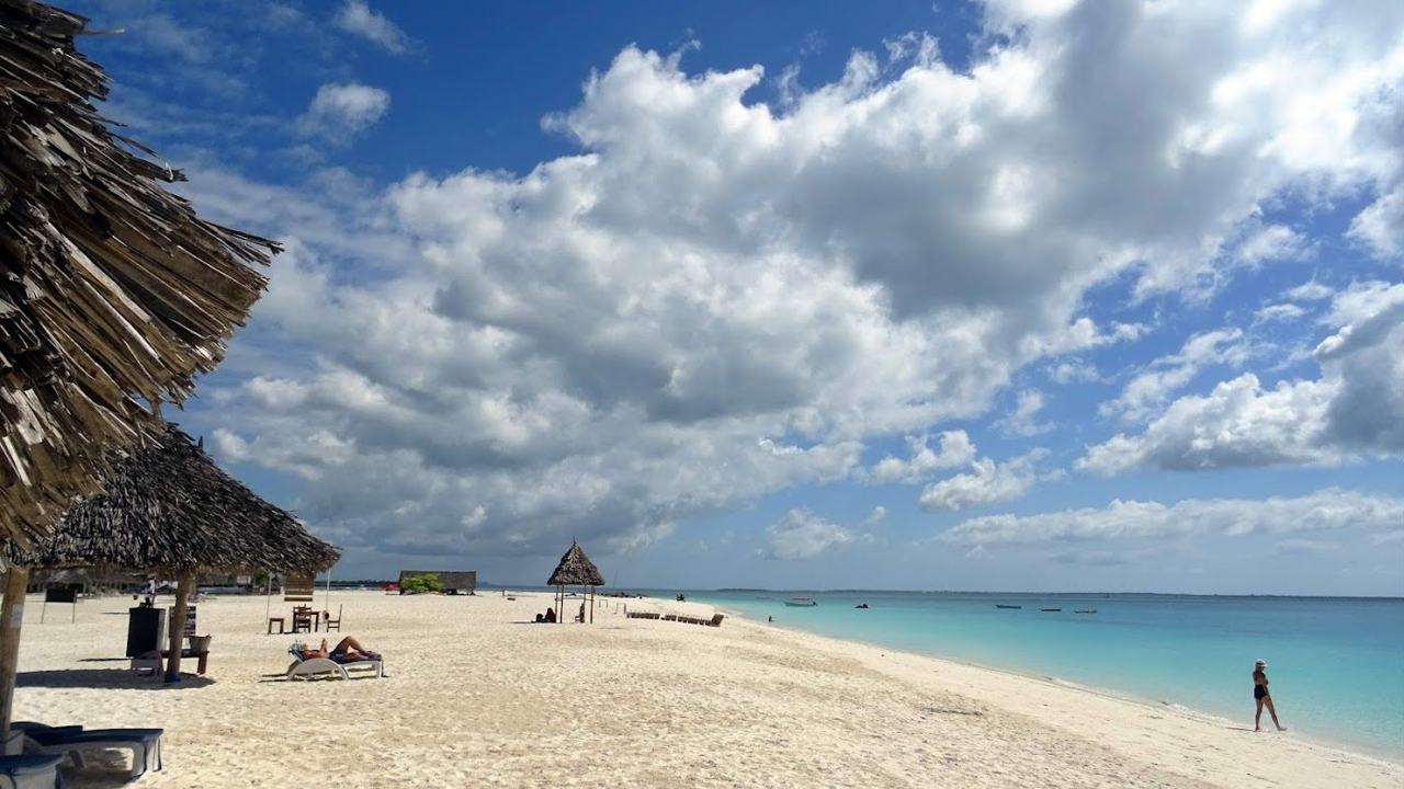 Broad powder white sand on the island's northern tip, swimmable through the tidal cycle.