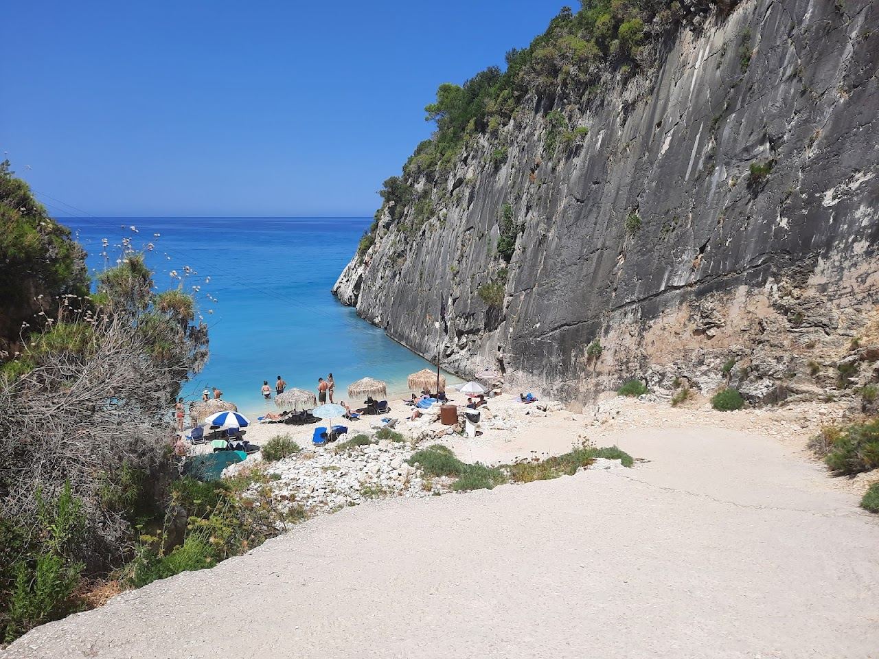 Clear deep water in the small pebble cove of Xigia sulphur beach below steep green cliffs on the north coast of Zakynthos
