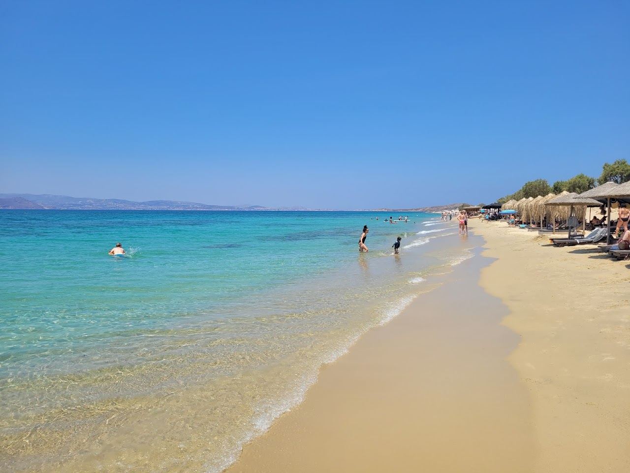 The long stretch of golden sand and calm clear water along Plaka beach on the southwest coast of Naxos